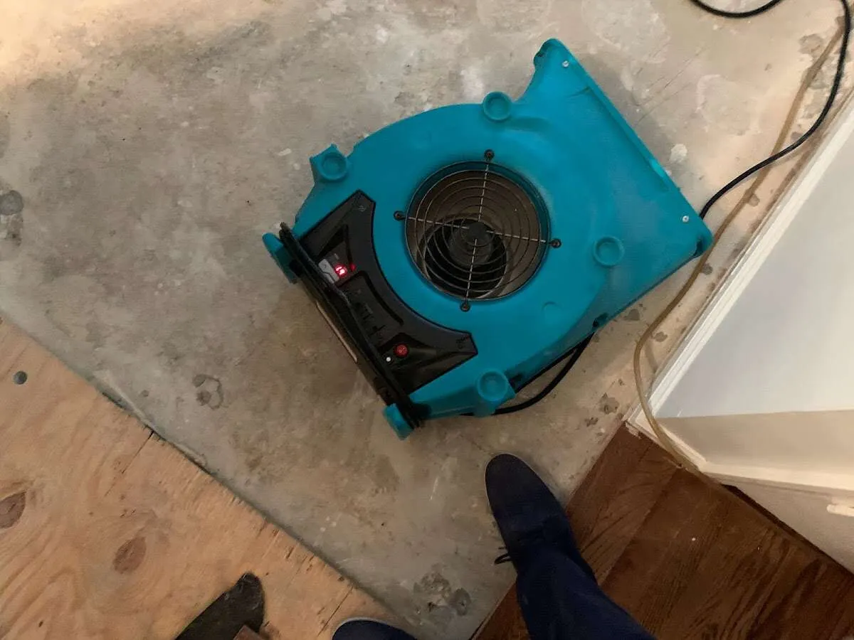 Air mover drying subfloor during Commercial Water Damage Restoration in Savage